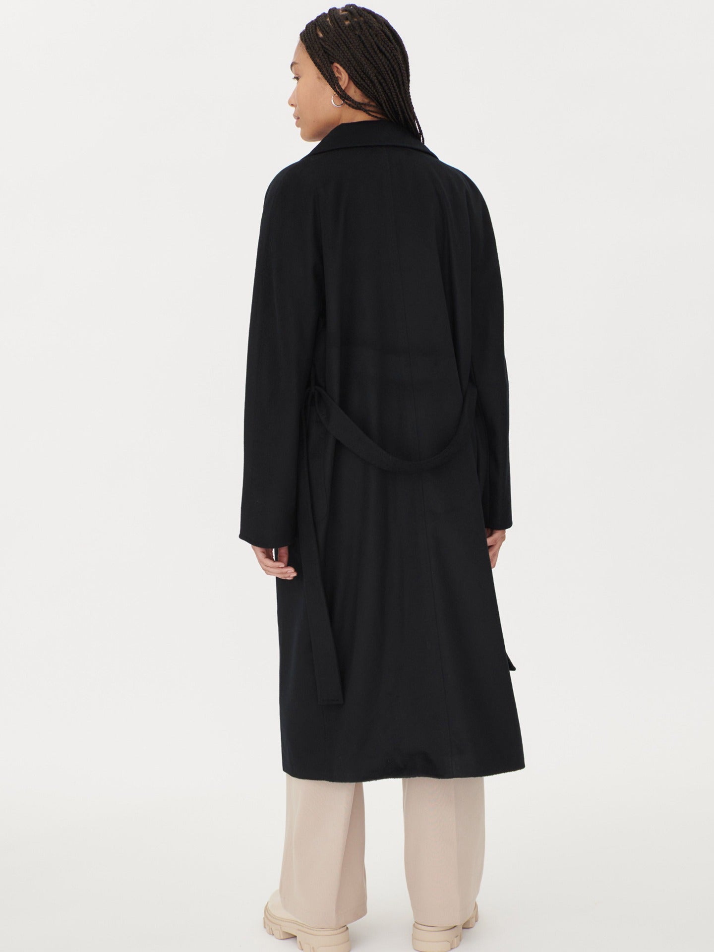 A model wearing a warm cashmere coat, styled with a belted waist for an elegant and cozy look.