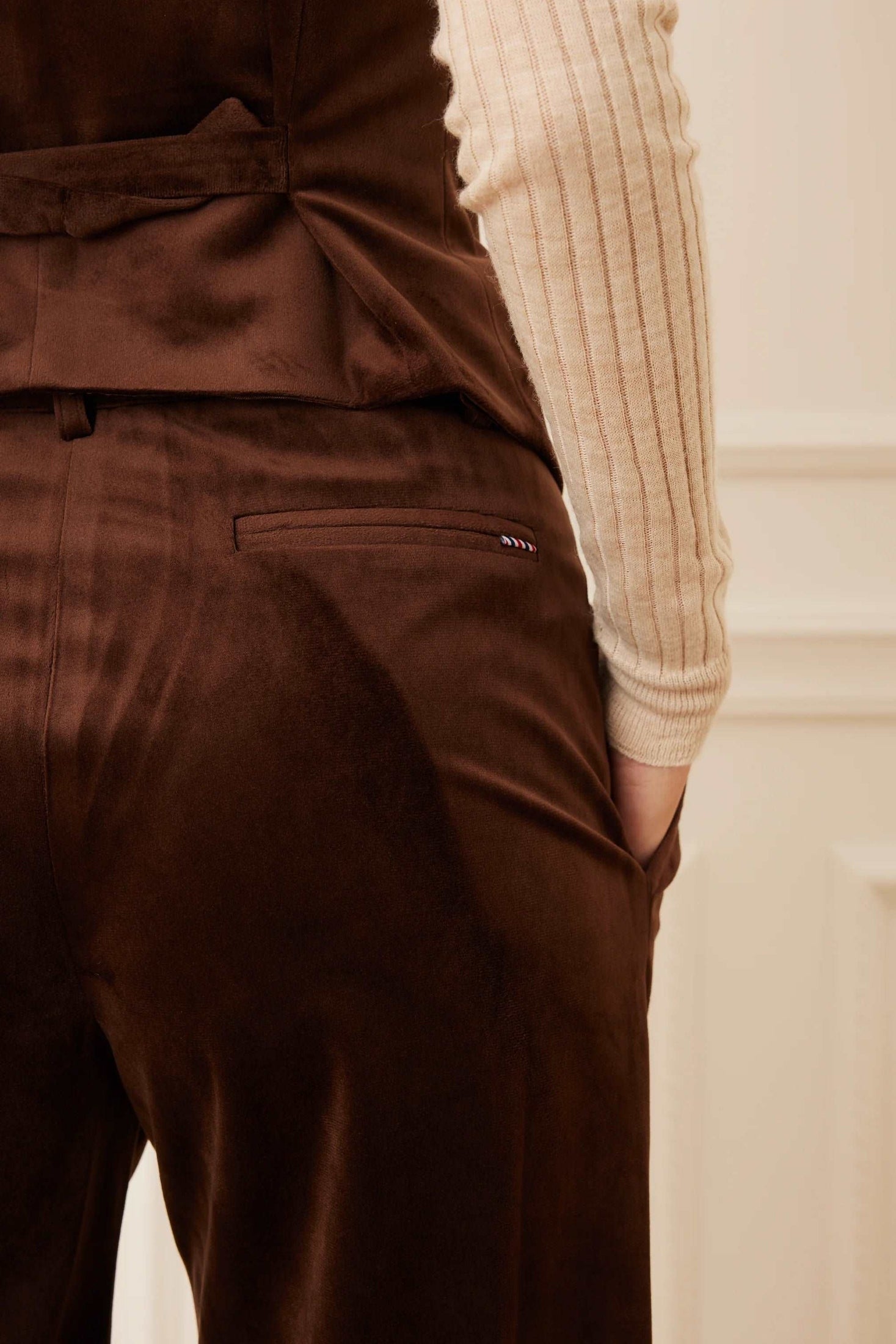 Close-up of the back pocket detail on brown velour pants.