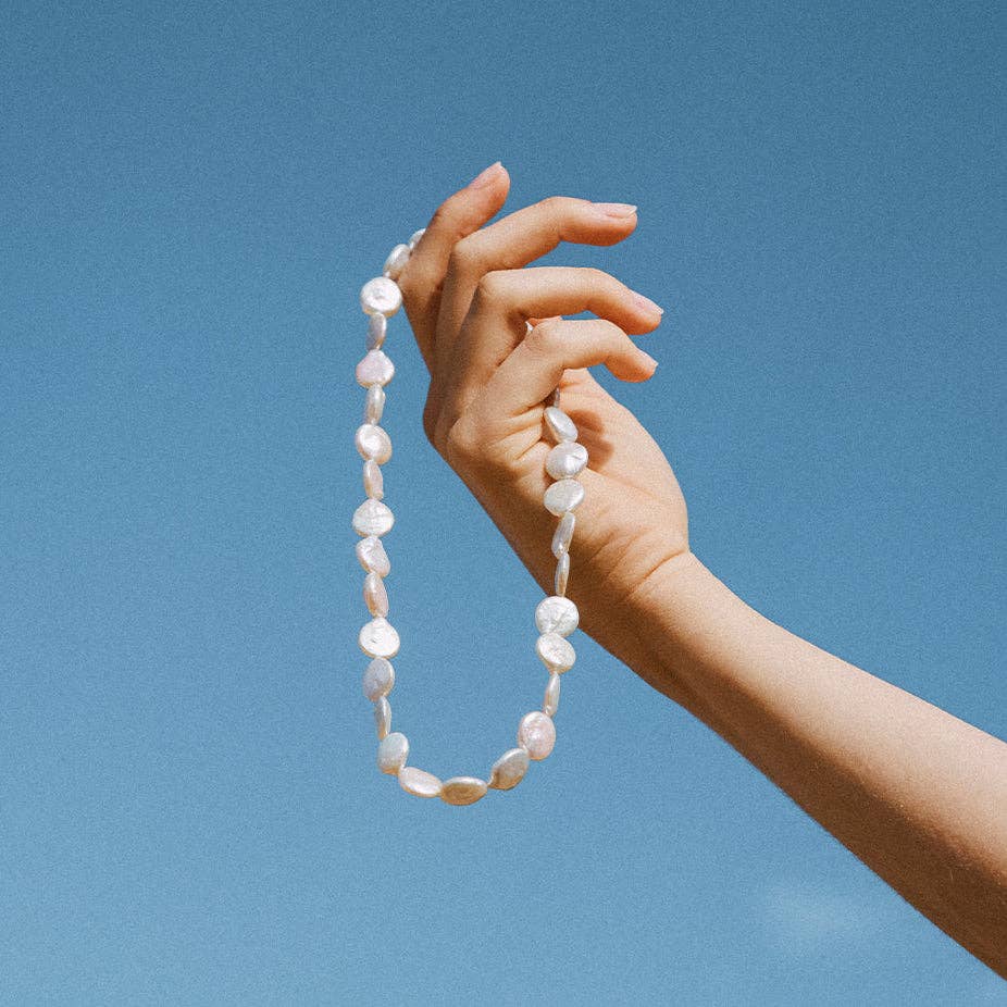 a coin-shaped pearl necklace, showcasing its unique and refined design.