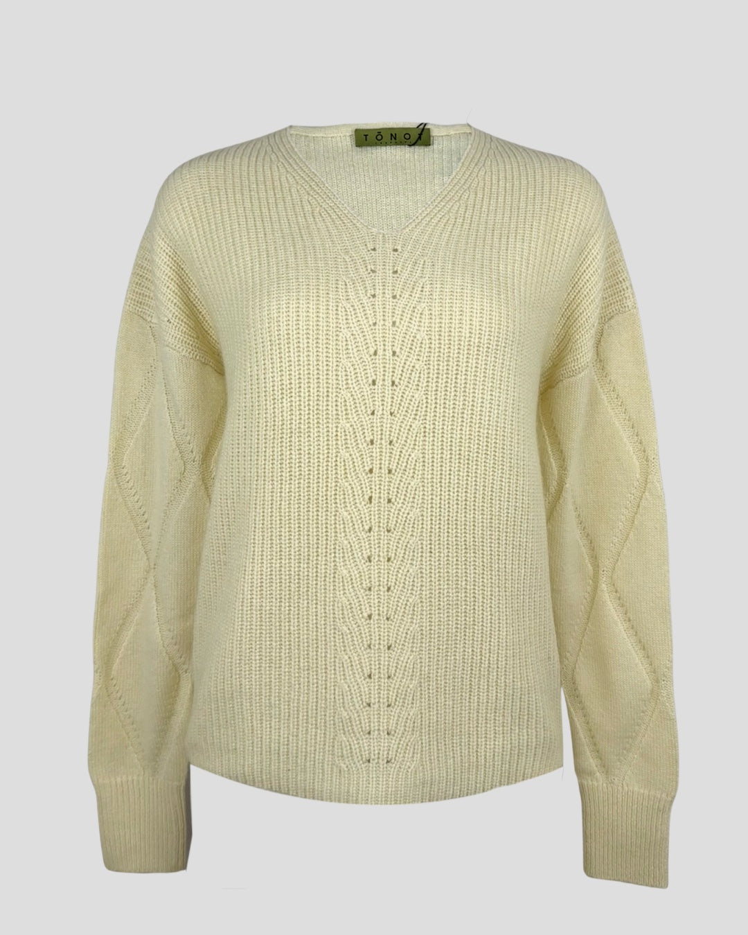 Cream knit cashmere sweater  v-neckline, long sleeves photographed flat on a light background.
